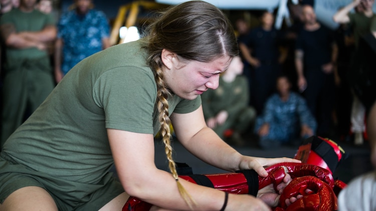 Lance Cpl. Christine Sanders practices a take-down technique after being sprayed with oleoresin capsicum aboard the USS Essex on the Indian Ocean, Oct. 31, 2015 during a non-lethal weapons course. Sanders is a water support technician with Combat Logistics Battalion 15, 15th Marine Expeditionary Unit. U.S. Marines and Sailors were sprayed across the face with OC spray and went through a series of exercises as their final event of the course. 