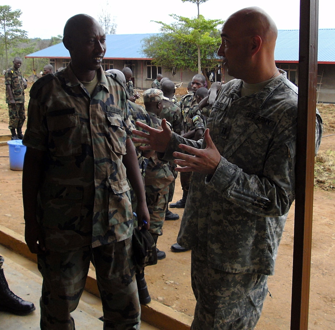 Army Capt. Kevin Cadena, 1st Battalion, 161st Field Artillery, Kansas Army National Guard, discusses task organization with a Rwanda Defense Force company commander during a break after class at the Gako Military Academy in Gako, Rwanda, October 19, 2011. Cadena along with other Soldiers from Combined Joint Task Force - Horn of Africa traveled to Gako to share leadership skills with the RDF.