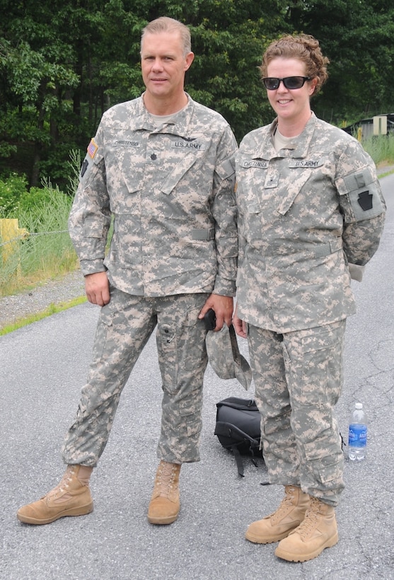 Pennsylvania Army National Guard members Lt. Col. Kelvin Christensen and Chief Warrant Officer 2 Sara Christensen stand at an aviation training site at Fort Indiantown Gap, Pa., in 2013 shortly after Sara returned to the Army after a 13-year break in service. Pennsylvania Army National Guard photo by Sgt. Neil Gussman
