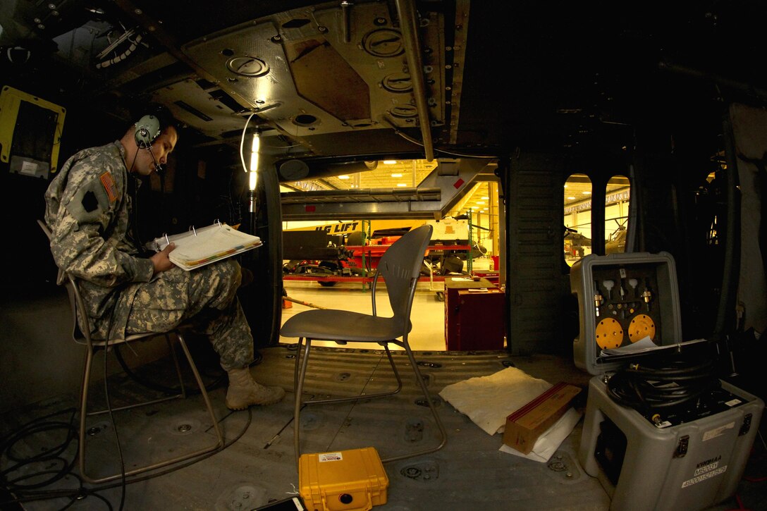 Army Sgt. Stephen Beechnox reads over technical manual during a hydraulics test on a UH-60 Black Hawk helicopter on Joint Base McGuire-Dix-Lakehurst, N.J., Oct. 28, 2015. Beechnox is an avionics technician assigned to the New Jersey Army National Guard. New Jersey Air National Guard photo by Tech. Sgt. Matt Hecht 