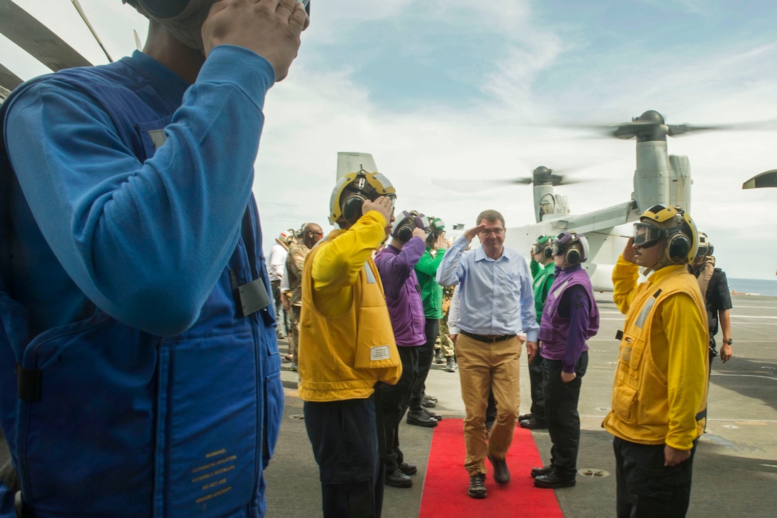 U.S. Defense Secretary Ash Carter salutes U.S. sailors during a visit aboard the USS Theodore Roosevelt at sea, Nov. 5, 2015. Carter toured the aircraft carrier with Malaysian Defense Minister Hishammuddin Hussein. DoD photo by Air Force Senior Master Sgt. Adrian Cadiz
