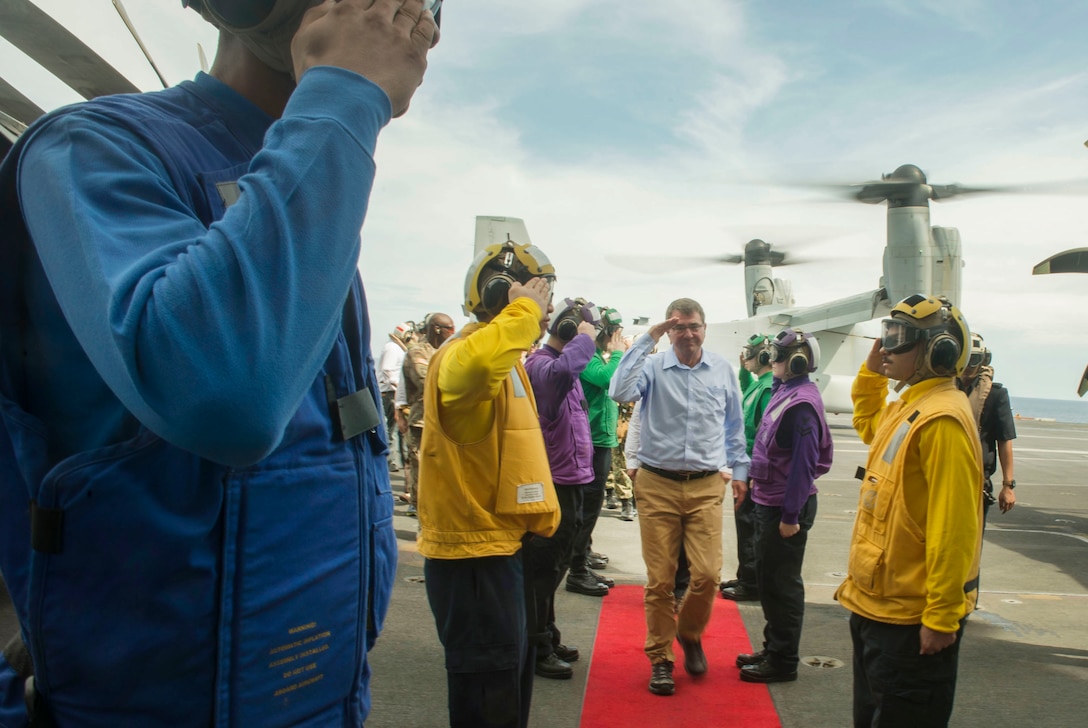 U.S. Defense Secretary Ash Carter returns a salute to U.S. sailors as he and Malaysian Defense Minister Hishammuddin Hussein arrive on the USS Theodore Roosevelt for a visit, Nov. 5, 2015. DoD photo by Air Force Senior Master Sgt. Adrian Cadiz