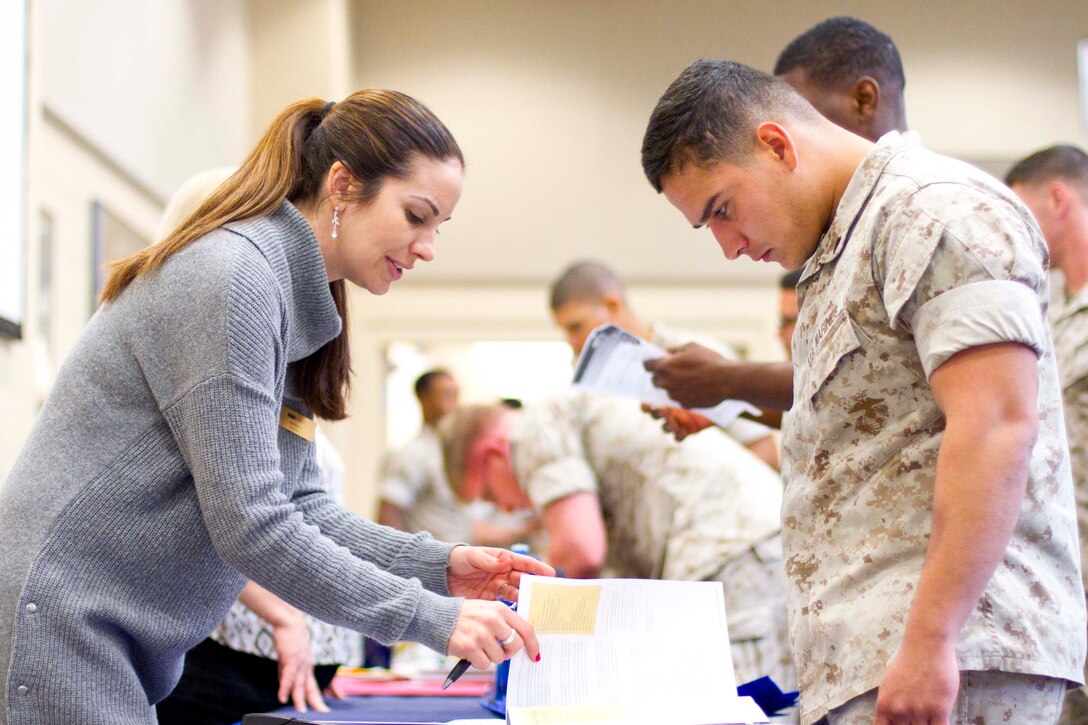 Cpl. Daniel Rios, right, trainer instructor at The Basic School, speaks to Keri Reams, military education coordinator for the University of Maryland University College, during a college fair Oct. 27 in Haywood Hall at The Basic School. After four years on active duty, Rios is taking the first steps beginning a degree in General Education.  