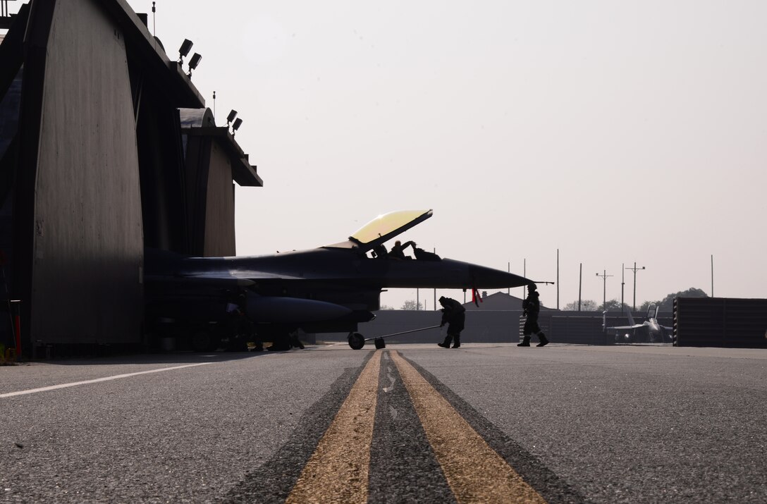 Airmen assigned to the 36th Aircraft Maintenance Unit push an F-16 Fighting Falcon assigned to the 36th Fighter Squadron inside a hardened facility Nov. 4, 2015, at Osan Air Base, Republic of Korea. The 36th FS is executing both day and night sorties during Vigilant Ace 16, challenging maintenance members to work around the clock in order to meet required mission sets. Vigilant Ace 16 is a large-scale exercise designed to enhance the interoperability of the U.S. and Republic of Korea Air Forces. (U.S. Air Force photo/Staff Sgt. Benjamin Sutton)