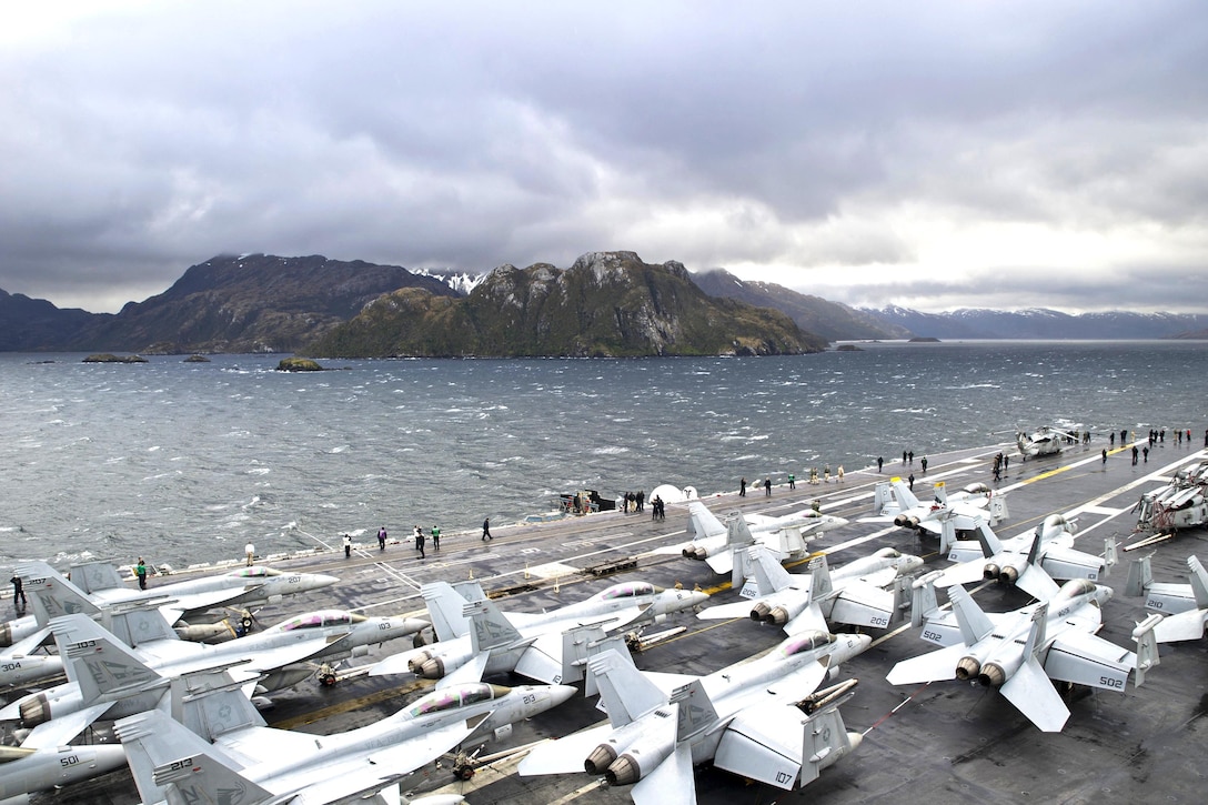 U.S. sailors take photos on the flight deck of the USS George Washington as it transits the Strait of Magellan on the southern tip of South America, Nov. 1, 2015. The George Washington is deployed as part of Southern Seas 2015, which seeks to enhance interoperability, increase regional stability and build and maintain regional relationships with countries throughout the region. U.S. Navy photo by Petty Officer 3rd Class Bryan Mai