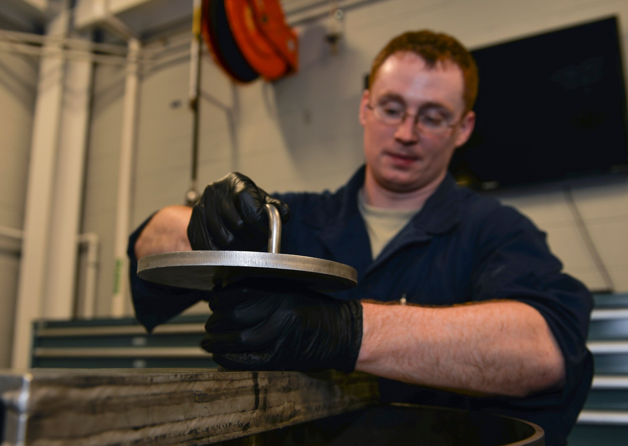 Senior Airmen Kenneth Chandler, 33rd Maintenance Squadron crew chief, turns the handle of a metal rod to “break the bead” of a tire at Eglin Air Force Base, Fla., Nov. 4, 2015. These tools assist maintenance Airmen to properly position the tire on the wheel. (U.S. Air Force Photo/Senior Airman Andrea Posey)