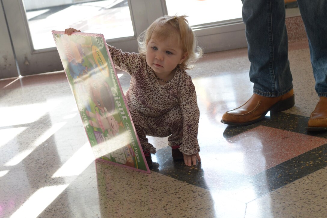 Kalista, 14 months, enjoys a giant coloring book handed out at Marine Corps Community Services’s trick or treating event in Little Hall aboard Marine Corps Base Quantico on Oct. 29. 