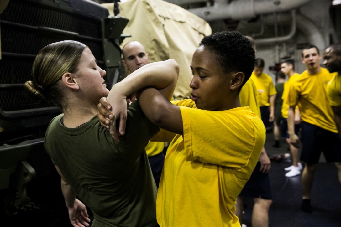 GULF OF OMAN (Oct. 30, 2015) U.S. Marine Lance Cpl. Breeann Rogers, Left, and a U.S. Sailor with the Essex Amphibious Ready Group, practice a take-down technique during a non-lethal force course aboard the amphibious assault ship USS Essex (LHD 2). Rogers a motor transportation operator with Combat Logistics Battalion 15, 15th Marine Expeditionary Unit and is a member of the combat cargo platoon. This course increases the Marine and Sailor watch-stander’s confidence to utilize different non-lethal techniques on aggressors. (U.S. Marine Corps photo by Sgt. Anna Albrecht/Released)