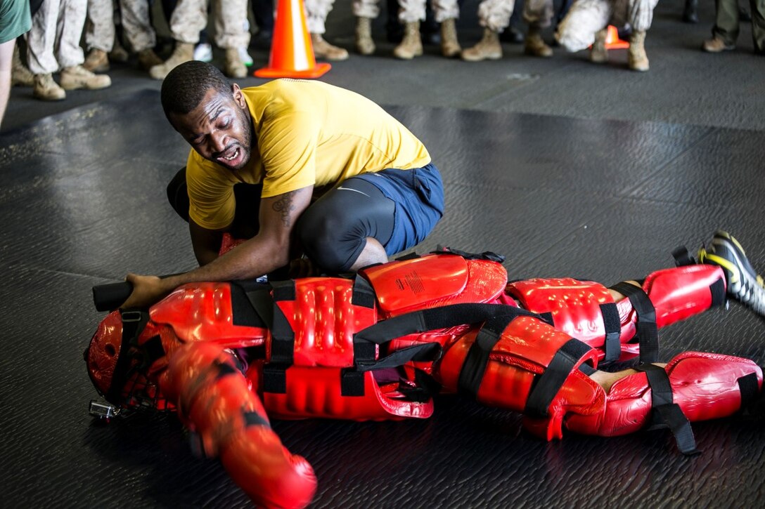 INDIAN OCEAN (Oct. 31, 2015) A U.S. Sailor with the Essex Amphibious Ready Group executes a take-down technique after being sprayed with oleoresin capsicum during a non-lethal weapons course aboard the amphibious assault ship USS Essex (LHD 2). U.S. Marines and Sailors were sprayed across the face with OC spray and went through a series of exercises as their final event of the course. (U.S. Marine Corps photo by Sgt. Anna Albrecht/ Released)