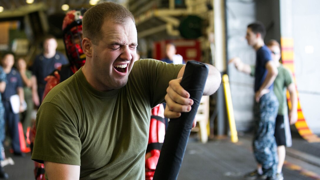 Sgt. Benjamin Stewart practices baton techniques after being sprayed with oleoresin capsicum aboard the USS Essex on the Indian Ocean, Oct. 31, 2015 during a non-lethal weapons course. Stewart is an intelligence specialist with Combat Logistics Battalion 15, 15th Marine Expeditionary Unit. U.S. Marines and Sailors were sprayed across the face with OC spray and went through a series of exercises as their final event of the course. 