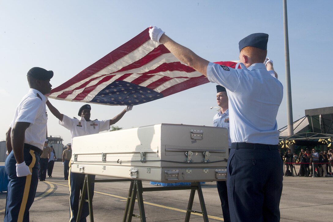 A joint service team drapes an American flag over a casket during a repatriation ceremony at Subang Air Base, Malaysia, Nov. 5, 2015. The 15-member team comprised of members of the Defense POW/MIA Accounting Agency as well service members from United States Army Pacific and Pacific Air Force was sent from Hawaii to honor the remains of a fallen service member who paid the ultimate sacrifice when his plane went down over Malaysia in 1945. The ceremony signifies the transfer of the remains from Malaysia back to the U.S. where the service member can be returned home. The ceremony marks the first of its kind between the two countries. The mission of the Defense POW/MIA Accounting Agency is to provide the fullest possible accounting for our missing personnel to their families and the nation. (U.S. Air Force photo by Staff Sgt. Brian J. Valencia)