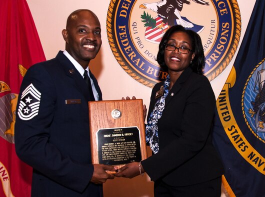 Chief Master Sgt. Cameron Kirksey, Air Force Reserve Command command chief, receives a plaque from Darlene Dew, United States Penitentiary Atlanta warden, after his Veteran’s Day speech at USP Atlanta, Ga. Nov. 5, 2015. Kirksey spoke to a crowd of around 150 U.S. Armed Force veterans. (U.S. Air Force photo/Staff Sgt. Daniel Phelps)