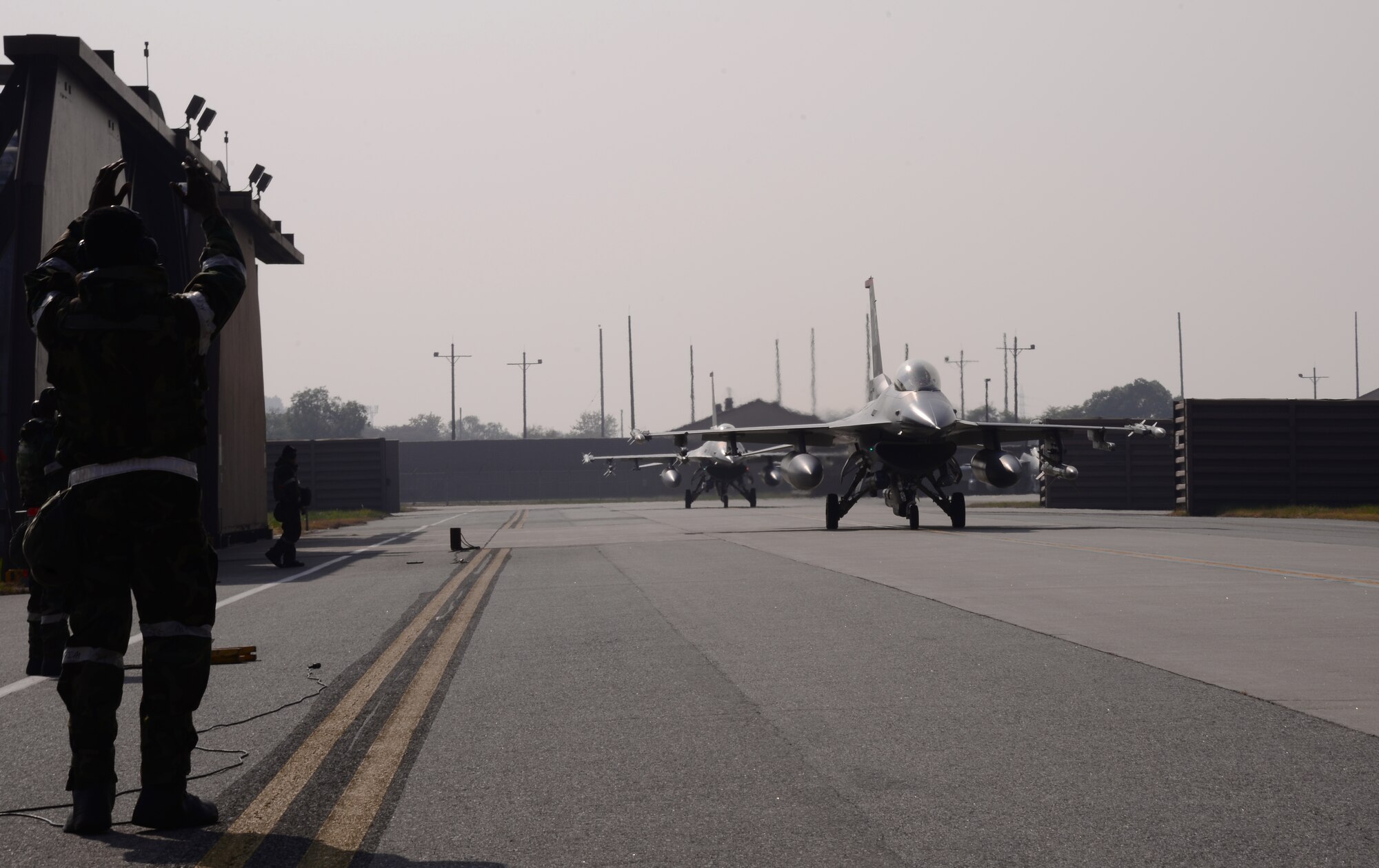 Senior Airman Jordan Cotton, 36th Aircraft Maintenance Unit assistant dedicated crew chief, directs an F-16 Fighting Falcon assigned to the 36th Fighter Squadron to a stop Nov. 4, 2015, at Osan Air Base, Republic of Korea. The Fiends are participating in readiness exercise Vigilant Ace 16. Vigilant Ace 16 is a large-scale exercise designed to enhance combat capabilities and interoperability of the U.S. and Republic of Korea Air Forces. (U.S. Air Force photo/Staff Sgt. Benjamin Sutton)