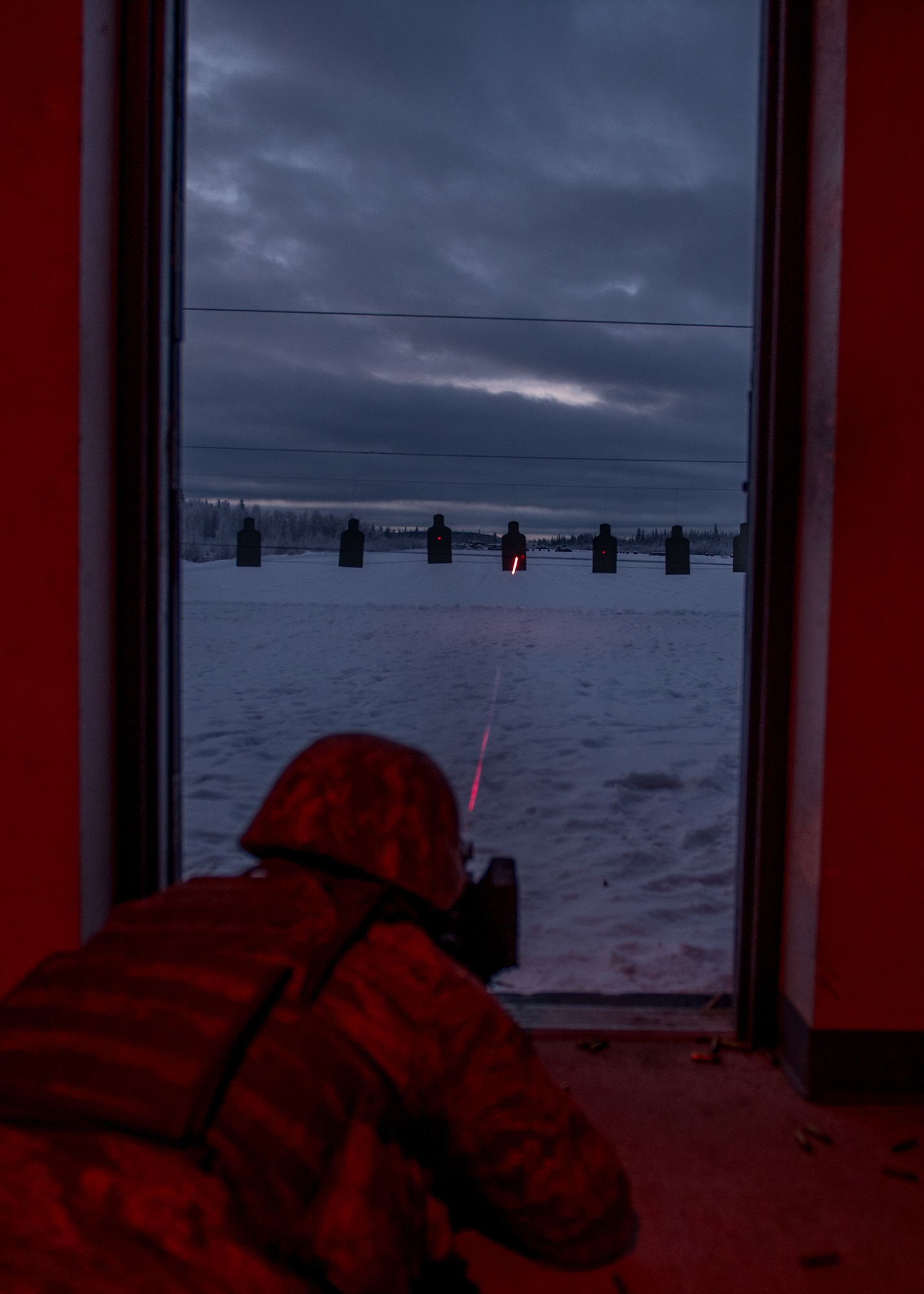 Airman 1st Class Daniel Reyes, a 354th Security Forces Squadron response force member, fires a tracer round at a paper silhouette target while using a laser sight during a low-light shooting course Nov. 4, 2015, at the Eielson Air Force Base, Alaska, combat arms training range. The course of fire also utilized night vision goggles, which was a first-time experience for Reyes and three other members of the squadron. (U.S. Air Force photo by Staff Sgt. Shawn Nickel/Released)