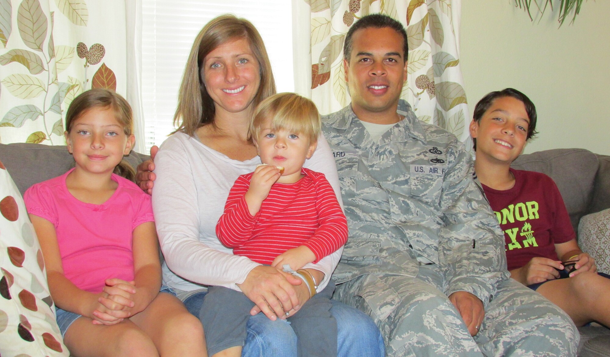 The Leonards, from left, 8-year-old Sofie, Jessica, 2-year-old Julian, James and 12-year-old Jayden, gather in their living room. They thanked the many members of Team Kirtland who supported their recent fundraising for pediatric cancer research, allowing Julian, who has cancer, to throw the first pitch at a Chicago Cubs game. (Photo by Argen Duncan)