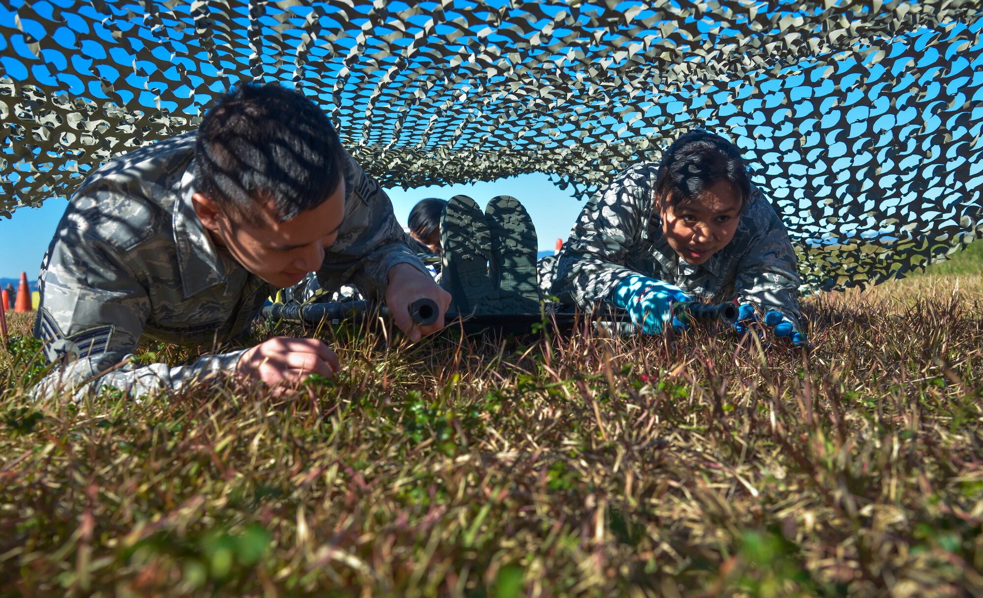 Airmen from the 374th Medical Group low crawl with a patient litter through an obstacle course during a medical evacuation training scenario at Yokota Air Base, Japan, Nov. 4, 2015. The medical evacuation training was completed as part of the Samurai Readiness Inspection being conducted in conjunction with the wing’s participation in Exercise VIGILANT ACE 16, a U.S.-Republic of Korea combined exercise aimed at enhancing operational and tactical level coordination through combined and joint combat training. (U.S. Air Force photo by Senior Airman David Owsianka/Released)