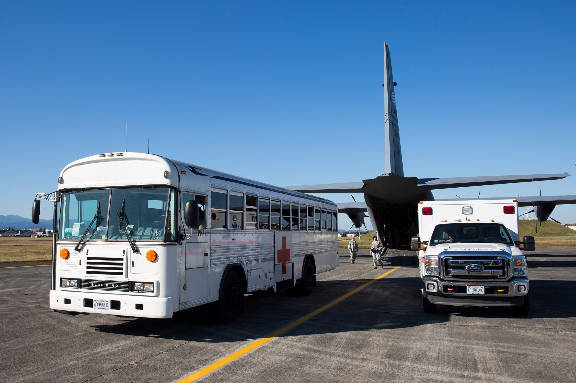 An ambulance and medical bus with the 374th Medical Group are ready to transport simulated victims from a C-130J at Yokota Air Base, Japan, Nov. 4, 2015. 
As the Western Pacific mobility hub, Yokota Air Base will be a key location in the event of regional instability, and this exercise gives the installation a chance to test those capabilities in a realistic scenario.  (U.S. Air Force photo by Osakabe Yasuo/Released)
