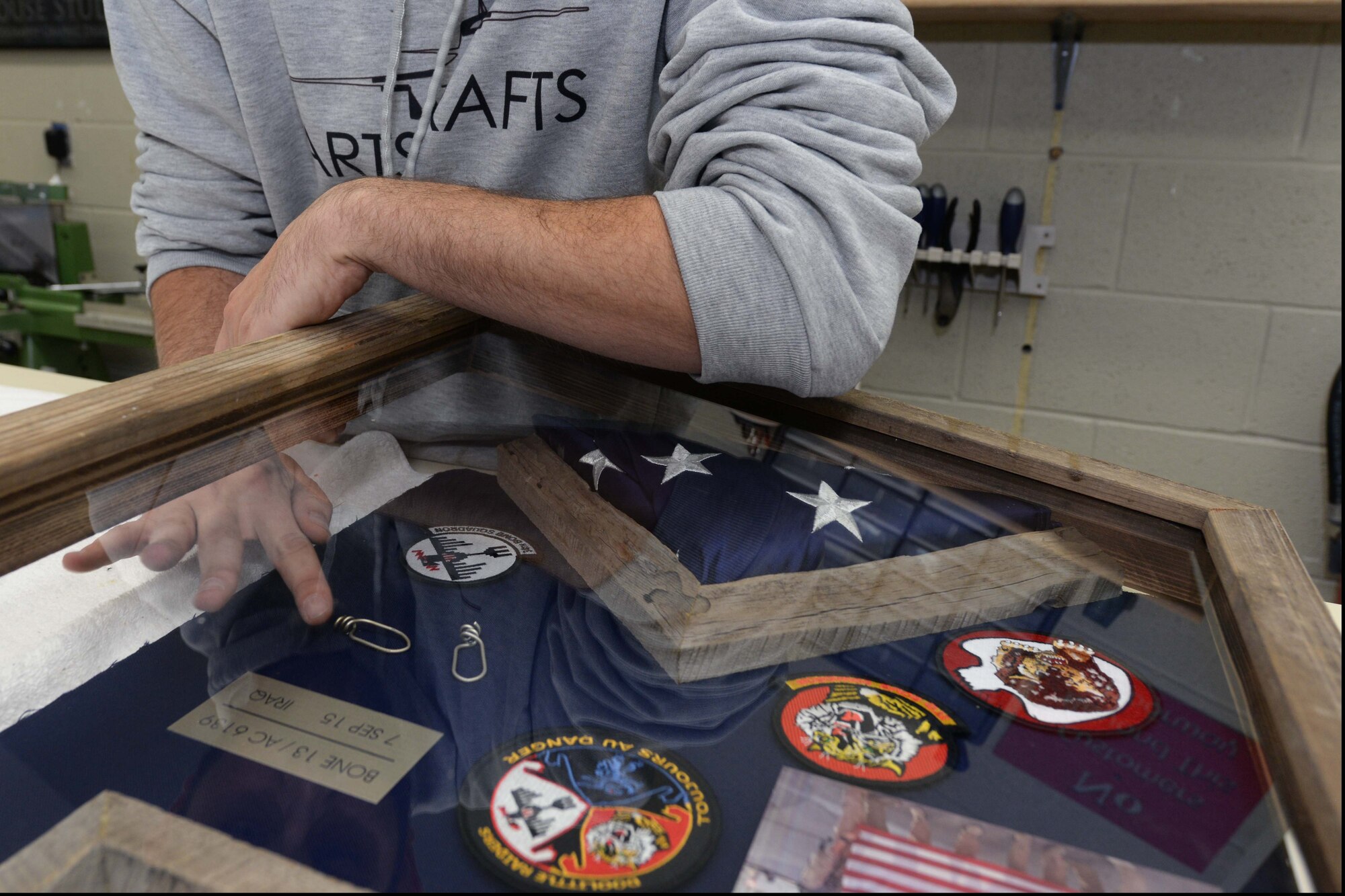 Joe Altergott, 28th Force Support Squadron visual information specialist, puts the finishing touches on a shadowbox at Ellsworth Air Force Base, S.D., Oct. 30, 2015. The box included an American flag, among other items, was presented to retired Lt. Col. Dick Cole, one of two surviving Doolittle Raiders, as a way to express Ellsworth’s gratitude and appreciation to him and all Tokyo Raiders. (U.S. Air Force photo by Senior Airman Rebecca Imwalle/Released)