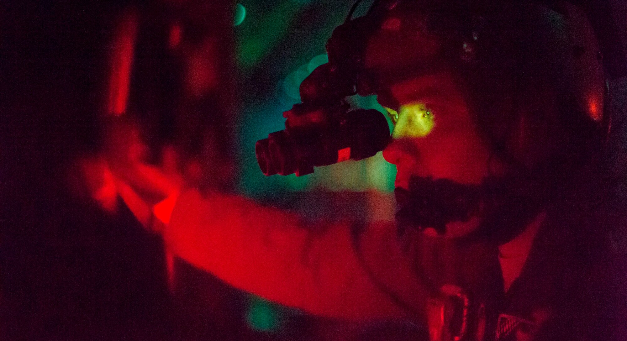 A U.S. Air Force C-130J Super Hercules pilot looks out a window of a C-130J Super Hercules, Oct. 30, 2015, above Powidz Air Base, Poland. Loadmasters must train at night to familiarize themselves to the aircraft in low-light situations. (U.S. Air Force photo/Senior Airman Damon Kasberg)