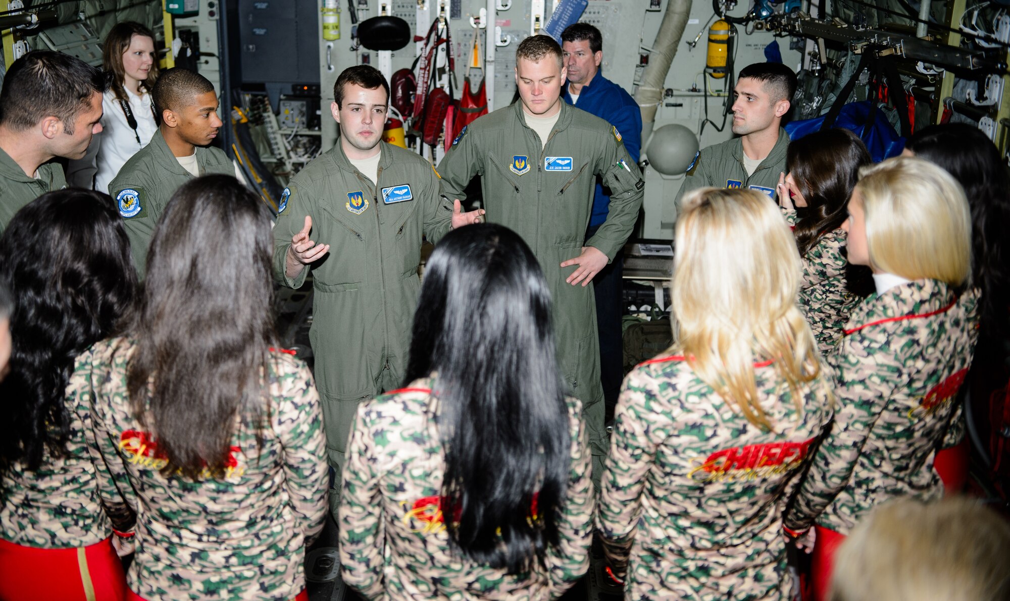 Airmen from the 37th Airlift Squadron explain their mission to the Kansas City Chiefs cheerleaders Nov. 2, 2015, at Ramstein Air Base, Germany. The base hosted the cheerleaders to explain how Ramstein supports and conducts the Air Force mission. (U.S.  Air Force photo/Staff Sgt. Armando A. Schwier-Morales)