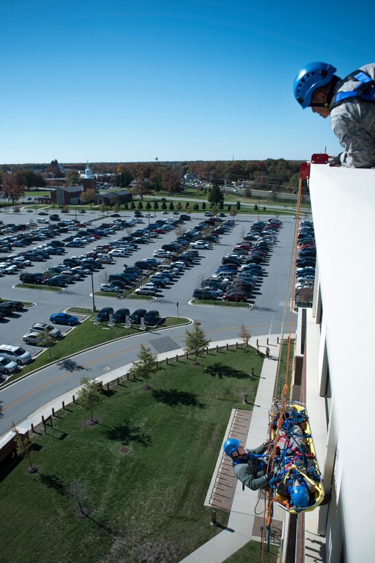 Firefighters from the 11th Civil Engineer Squadron are lifted up the side of the William A. Jones III Building on Joint Base Andrews, Md., during a Department of Defense Rescue Technical Course, Oct. 10, 2015. Ten members of the 11 CES Fire Department went through a 15-day advanced rescue course on base taught by DOD rescue instructors from Goodfellow Air Force Base, Texas. The course included confined space rescue training and ropes skills training. (U.S. Air Force photo by Airman 1st Class Philip Bryant/Released)