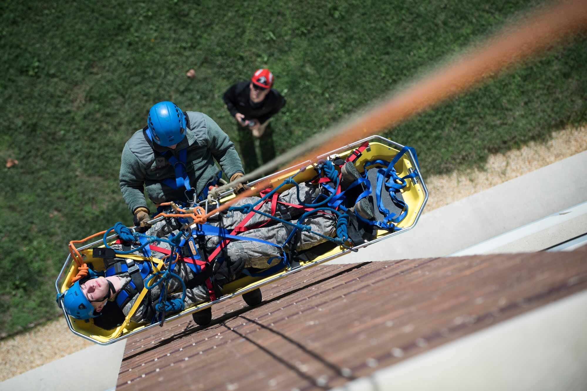 Senior Airman Adam St. Clair, 11th Civil Engineer Squadron fire department exercise recuse spotter, and Airman 1st Class Dean Adamczyk, 11 CES Fire Department exercise rescue patient, are lifted up the side of the Jones building on Joint Base Andrews, Md., during a Department of Defense Rescue Technical Course, Oct. 10, 2015. Staff Sgt. Adam McCarty and Staff Sgt. Alexander Rodriguez, DOD Fire Academy rescue instructors from Goodfellow Air Force Base, Texas, travelled to JBA to certify 10 members of 11 CES Fire Department in confined space rescue and rope skills training. (U.S. Air Force photo by Airman 1st Class Philip Bryant/Released)