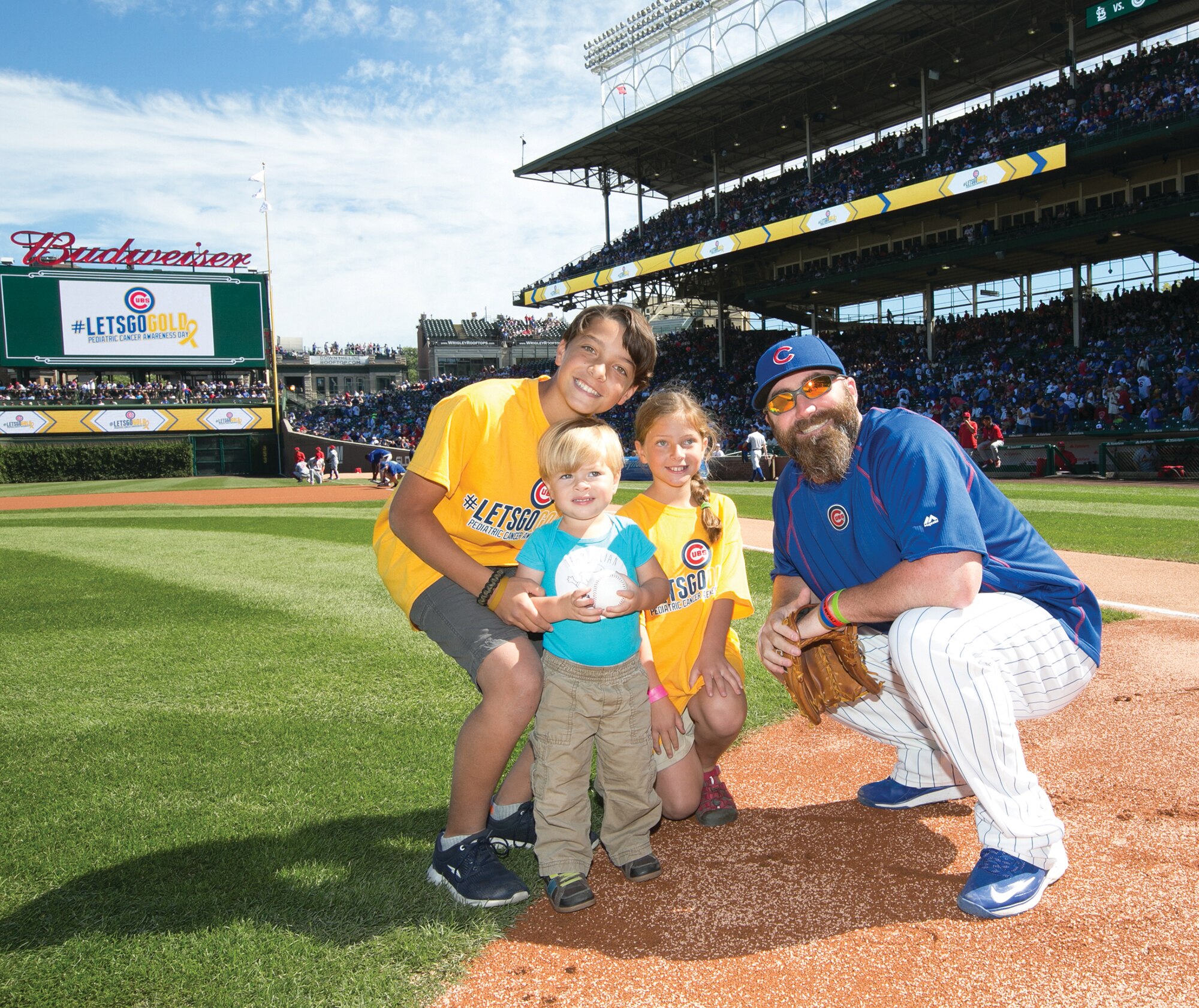 The Leonard children, from left, Jayden, Julian and Sofie, pose with Chicago Cubs relief pitcher Jason Motte before Julian throws the ceremonial first pitch to Motte in September in Chicago. (Courtesy photo)