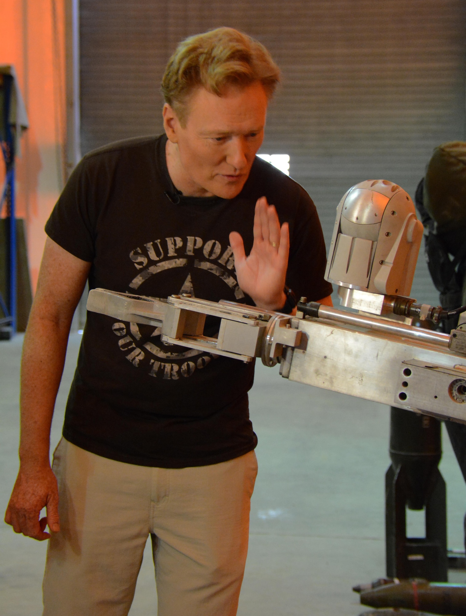 Late night talk show host and comedian, Conan O’Brien, talks to an F-6 robot inside the 379th Civil Engineer Squadron Explosive Ordnance Disposal facility at Al Udeid Air Base, Qatar Nov. 4. O'Brien received a tour of the facility during a base visit. He also put on a variety show for deployed service members and thanked them for all they do to defend America. (U.S. Air Force photo by Tech. Sgt. James Hodgman)