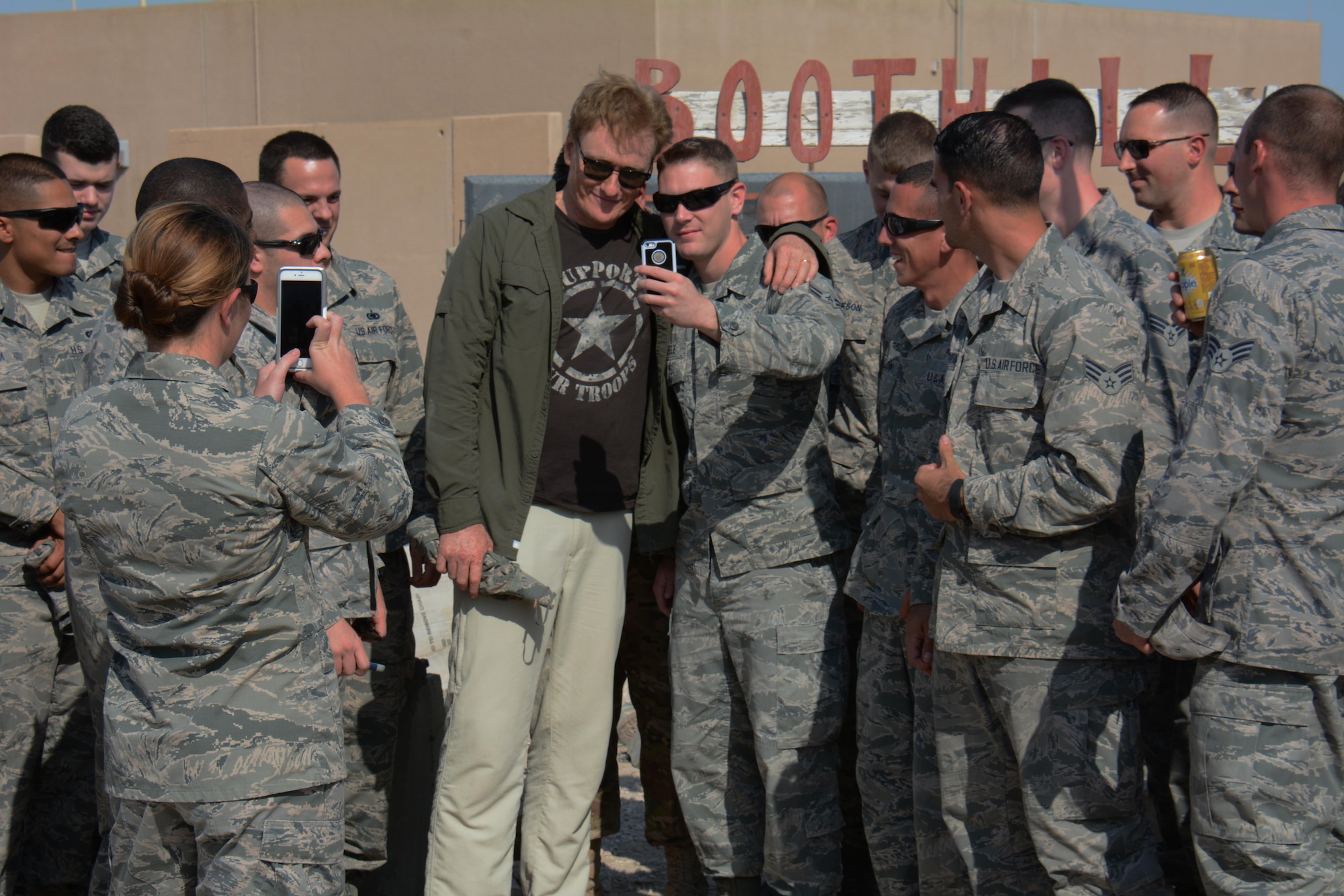 Late night talk show host and comedian, Conan O’Brien, poses for photos with several airmen at Al Udeid Air Base, Qatar Nov. 4. O’Brien visited AUAB to meet with and entertain service members. He said he was honored to visit with America’s warriors and thanked all service members for what they do to defend America’s freedom. (U.S. Air Force photo by Tech. Sgt. James Hodgman)