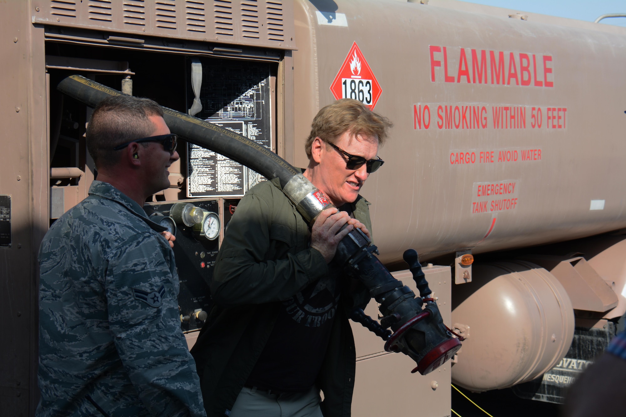 Late night talk show host and comedian, Conan O’Brien, attempts to haul a fuel line to an RC-135 Stratotanker at Al Udeid Air Base, Qatar Nov. 4 during a base visit. O’Brien visited AUAB to meet with and entertain service members. He said he was honored to spend time with America’s warriors and thanked all service members for what they do to defend America’s freedom. (U.S. Air Force photo by Tech. Sgt. James Hodgman)