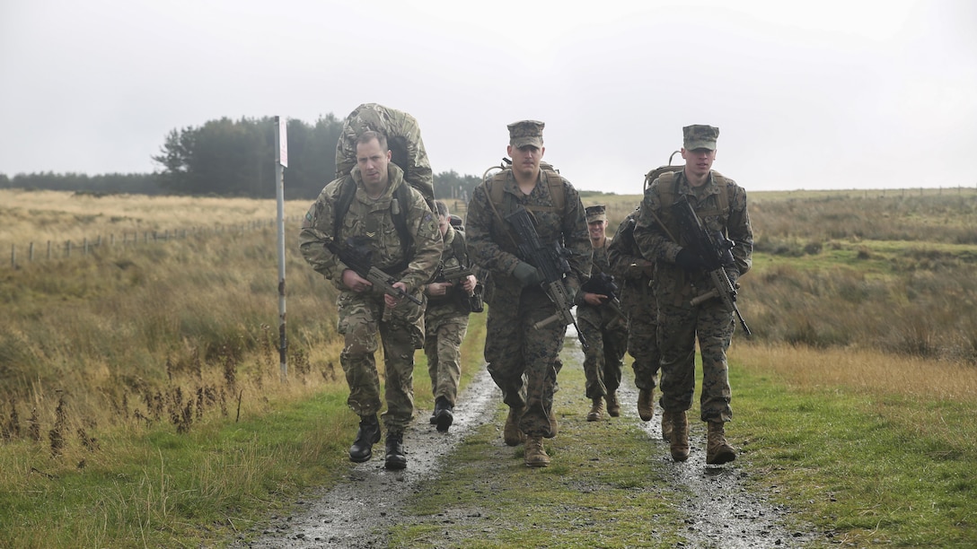 U.S. Marine Lance Cpl. Jason Shillingburg, center, and Lance Cpl. Mason Foth, right, execute a three-mile conditioning hike with other U.S. Marines and British soldiers during Exercise Phoenix Odyssey II near Edinburgh, U.K., Oct. 30, 2015. Shillingburg and Foth are both intelligence specialists with 2nd Intelligence Battalion. The Marines and their British counterparts are currently working to enhance joint intelligence operations and military skills for potential real-world contingencies. 