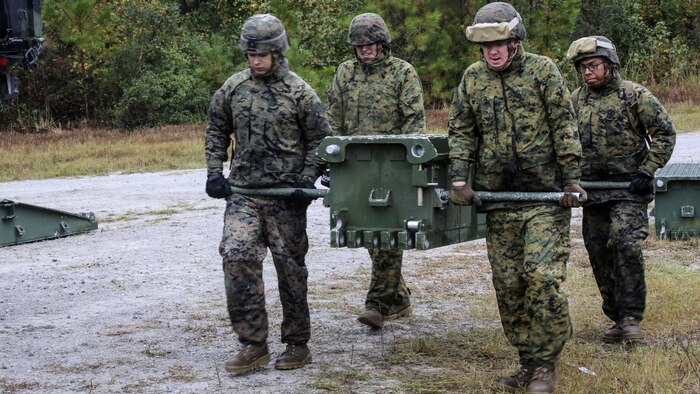 Marine students in the 8th Engineer Support Battalion Bridge Master’s Course lift a bridge bay during a field exercise at Marine Corps Base Camp Lejeune, N.C., Nov. 4, 2015. The course teaches Marines to lead the bridge building process, and is hosting Marines from 9th Engineer Support Battalion, 3rd Marine Logistics Group, based in Camp Hansen, Okinawa. During the exercise, Marines constructed and deconstructed a bridge 11 bays in length. 