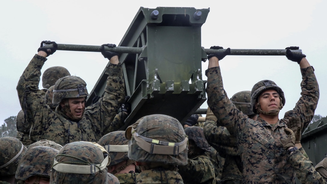 Marine students in the 8th Engineer Support Battalion Bridge Master’s Course lift a bridge bay during a field exercise at Marine Corps Base Camp Lejeune, N.C., Nov. 4, 2015. The course teaches Marines to lead the bridge building process, and is hosting Marines from 9th Engineer Support Battalion, 3rd Marine Logistics Group, based in Camp Hansen, Okinawa. Marines were required to work together to lift weight between 400 and 600 pounds.