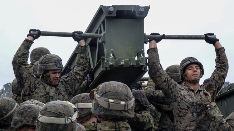 Marine students in the 8th Engineer Support Battalion Bridge Master’s Course lift a bridge bay during a field exercise at Marine Corps Base Camp Lejeune, N.C., Nov. 4, 2015. The course teaches Marines to lead the bridge building process, and is hosting Marines from 9th Engineer Support Battalion, 3rd Marine Logistics Group, based in Camp Hansen, Okinawa. Marines were required to work together to lift weight between 400 and 600 pounds.