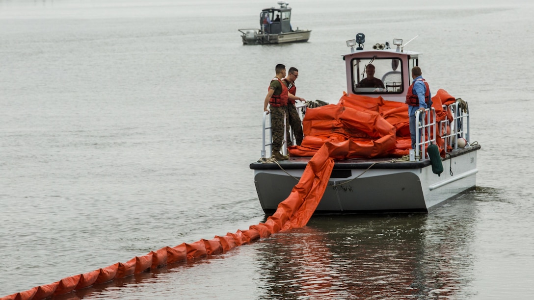 Marines and civilians use a boom to contain a simulated oil spill at Marine Corps Air Station Beaufort, S.C., Nov. 4, 2015. The boom is towed behind the boats and acts as a large net, trapping the oil to be collected by a skimmer boat. The Marines and civilians are with the Marine Corps Air Station Beaufort fuels sections and the Natural Resources Environmental Affairs Office.