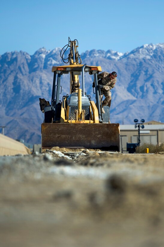 U.S. Air Force Tech. Sgt. David Blankenship inspects his backhoe at Bagram Airfield, Afghanistan, Nov. 4, 2015. Blankenship is a pavements and equipment technician assigned to the 455th Expeditionary Civil Engineer Squadron. U.S. Air Force photo by Tech. Sgt. Robert Cloys