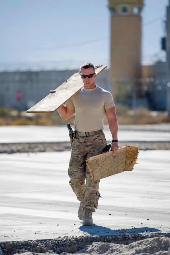 U.S. Air Force Airman 1st Class Patrick Chuba carries scrap wood to a construction site at Bagram Airfield, Afghanistan, Nov. 4, 2015. Chuba is a pavements and equipment technician assigned to the 455th Expeditionary Civil Engineer Squadron. U.S. Air Force photo by Tech. Sgt. Robert Cloys