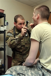 Army Maj. (Dr.) Tim Cheslock examines a patient at the primary care New Kabul Compound clinic in Afghanistan, where the former physician assistant is serving a primary care physician during the first deployment of his Army National Guard career.