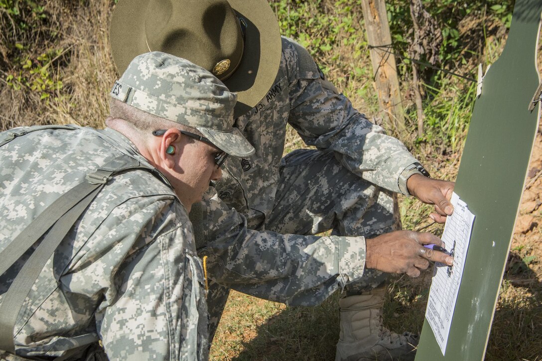 Army Sgt. 1st Class Ervin Brewster, rear, assesses the shot grouping of Trent Skates, a Clemson University Reserve Officer Training Corps cadet, during a leadership exercise in Clemson, S.C., Oct. 24, 2015. Brewster is an Army Reserve drill sergeant assigned to the 98th Training Division's Company D, 1st Battalion, 518th Infantry Regiment, 2nd Brigade Combat Team. U.S. Army photo by Sgt. Ken Scar