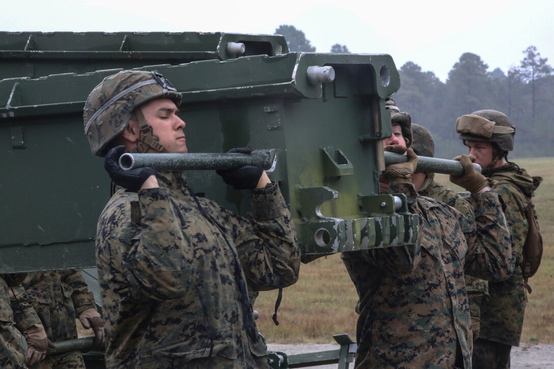 Marine students in the 8th Engineer Support Battalion Bridge Master’s Course lift a bridge bay during a field exercise at Camp Lejeune, N.C., Nov. 4, 2015. The course teaches Marines to lead the bridge building process, and is hosting Marines from 9th Engineer Support Battalion, 3rd Marine Logistics Group, based in Camp Hansen, Okinawa. During the exercise, Marines constructed and deconstructed a bridge eleven bays in length. (U.S. Marine Corps photo by Cpl. Paul S. Martinez/Released)