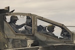 Apache AH-64D pilots go through their pre-flight checks at Silverbell Army Heliport before beginning an event during the Gunfighter-Fly In competition Nov. 3, 2015. The Gunfighter Fly-In pits some of the best AH-64D Apache attack helicopter crews from seven different Army National Guard units from across the nation in a competition to see who's best. Crews from Arizona, Utah, Idaho, South Carolina, North Carolina, Texas and Missouri competed for the top scores in various events such as a live-fire scenario, unmanned aerial systems teaming, simulator test and a written evaluation.