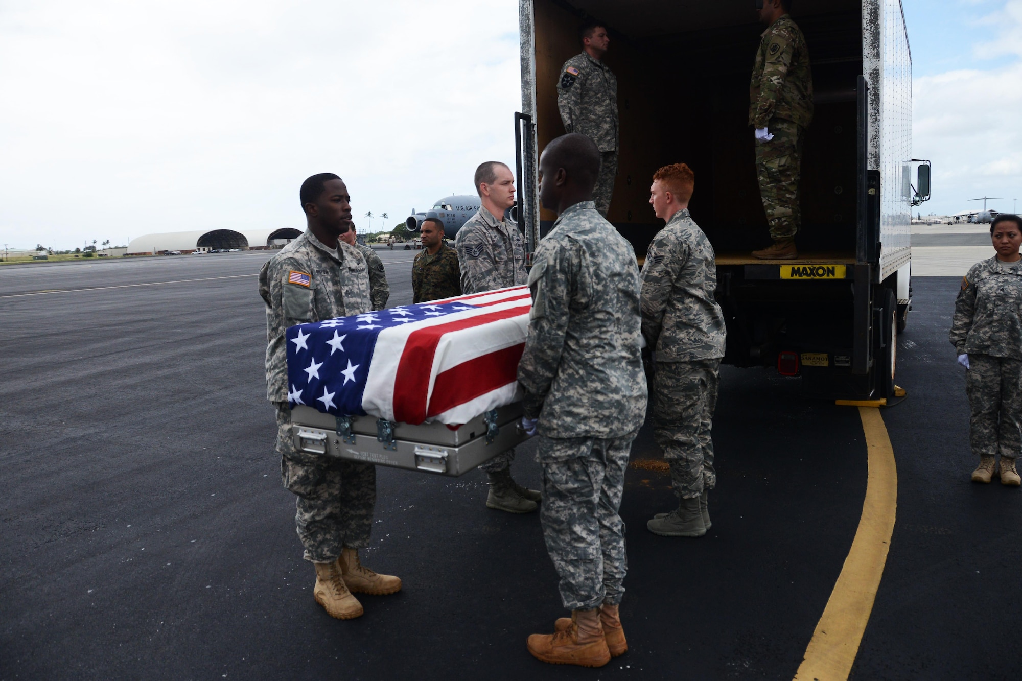 Honor guardsmen from the Defense POW/MIA Accounting Agency (DPAA) prepare to load a transfer case containing unidentified remains recovered and flown from Malaysia into a transport truck at Joint Base Pearl Harbor-Hickam, Hawaii, Nov. 5, 2015.  These remains will be received by DPAA’s forensic laboratory for identification. The DPAA mission is to provide the fullest possible accounting for our missing personnel from past conflicts to their families and the nation. (DOD photo by Spc Crystal Madriz/Released)