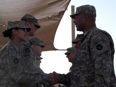 Army National Guard Spc. Arden Morales, a combat medic assigned to the Minnesota National Guard's 1st Squadron, 94th Cavalry, 1st Brigade Combat Team, 34th Infantry Division,receives congratulations from Army National Guardd Lt. Col. Eddie Frizell, commander of the 1st Squadron, 94th Cavalry for saving an Iraqi woman's life during a convoy mission from Khabari Crossing, Iraq to Camp Adder, Iraq, Oct. 15, 2011. The woman Moralez saved had been involved in a vehicle accident on her unit's convoy route.