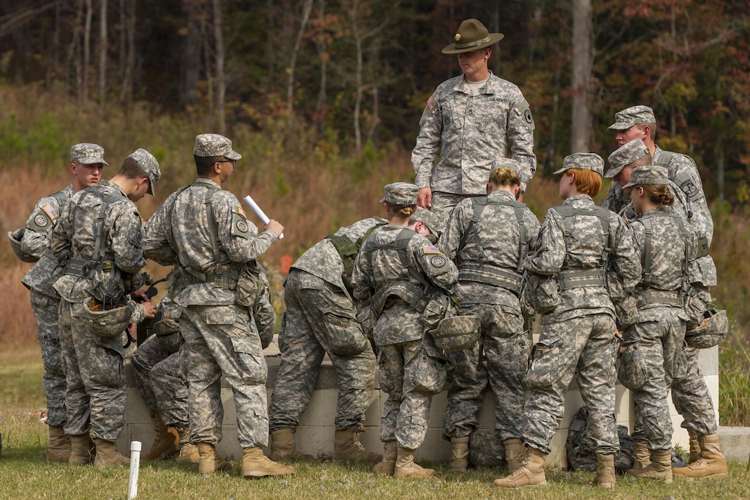 Army Sgt. Robin Brown, center, stands above a group of Clemson University Reserve Officer Training Corps cadets as he teaches them how to operate a ground and airborne radio system during a leadership exercise in Clemson, S.C., Oct. 24, 2015. Brown is an Army Reserve drill sergeant assigned to the 98th Training Division's Company D, 1st Battalion, 518th Infantry Regiment, 2nd Brigade Combat Team. U.S. Army photo by Sgt. Ken Scar