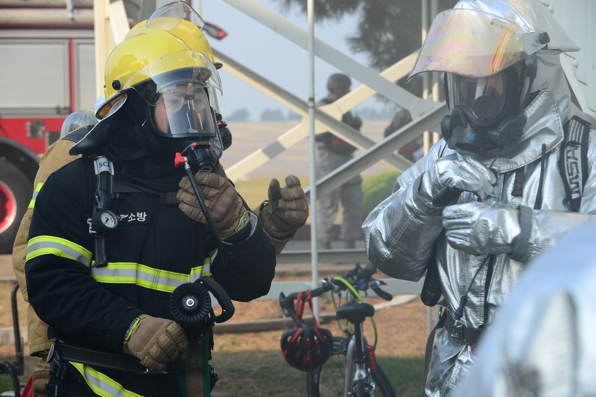 U.S. Air Force and Republic of Korea air force firefighters prepare to extinguish a structural fire during VIGILANT ACE 16 at Kunsan Air Base, ROK, Nov.2, 2015. VIGILANT ACE 16 is a regularly scheduled training event designed to enhance the readiness of U.S. and ROK forces. (U.S. Air Force photo by Senior Airman Ashley Gardner/Released)