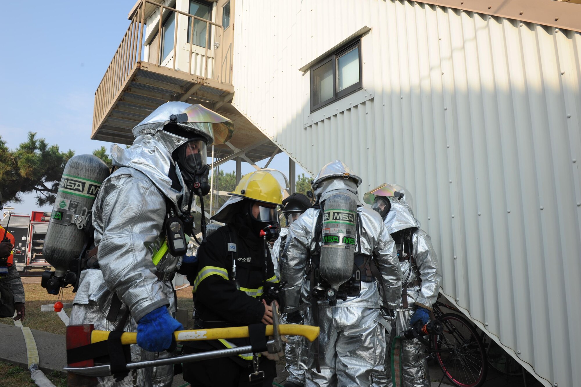 U.S. Air Force and Republic of Korea air force firefighters discuss tactics after extinguishing a structural fire during VIGILANT ACE 16, at Kunsan Air Base, ROK, Nov. 2, 2015. During this training exercise, U.S. and ROKAF firefighters combined to ensure interoperability and readiness of forces. (U.S. Air Force photo by Senior Airman Ashley Gardner/Released) 