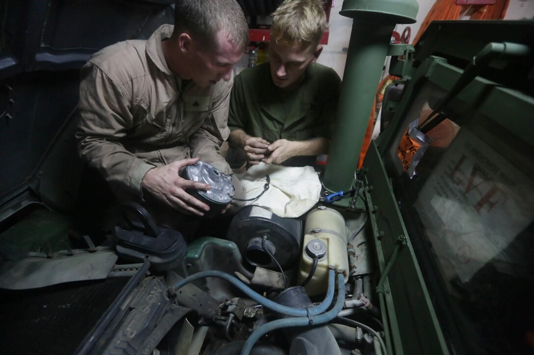 INDIAN OCEAN (Nov. 5, 2015) U.S. Marine Sgt. Carl Provost, right, and Cpl. Cody Stevens, left, replace an air-conditioning pump on a Humvee aboard the USS Anchorage (LPD 23). Stevens is a light armored vehicle mechanic with 1st Radio Battalion Detachment, 15th Marine Expeditionary Unit, and Provost is a maintenance chief with the 15th MEU. The 15th MEU is currently deployed in the Indo-Asia-Pacific region to promote regional stability and security in the U.S. 7th Fleet area of operations. (U.S. Marine Corps photo by Sgt. Jamean Berry/Released)