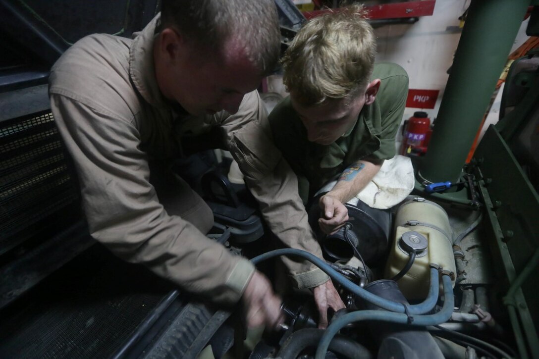 GULF OF ADEN (Nov. 5, 2015) U.S. Marine Sgt. Carl Provost, right, and Cpl. Cody Stevens install an air-conditioning pump on a Humvee aboard the USS Anchorage (LPD 23). Stevens is a light armored vehicle mechanic with 1st Radio Battalion Detachment, 15th Marine Expeditionary Unit, and Provost is a maintenance chief with the 15th MEU. The 15th MEU is currently deployed in the Indo-Asia-Pacific region to promote regional stability and security in the U.S. 7th Fleet area of operations. (U.S. Marine Corps photo by Sgt. Jamean Berry/Released)