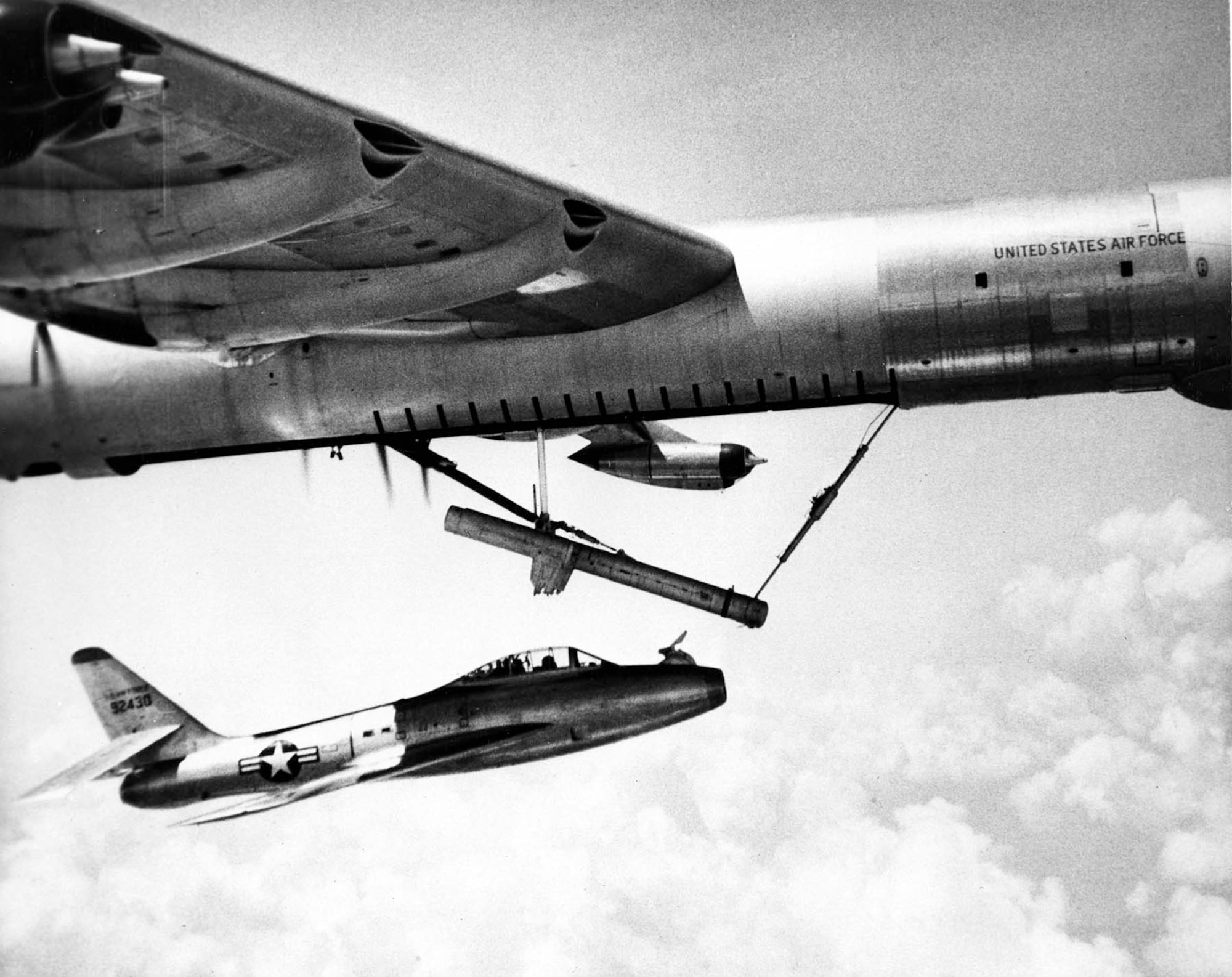 The YRF-84F flying underneath its B-36 carrier aircraft. FICON modifications included installing a hook in front of the cockpit and turning down the horizontal tail so it could partially fit into the B-36 bomb bay. (U.S. Air Force photo)