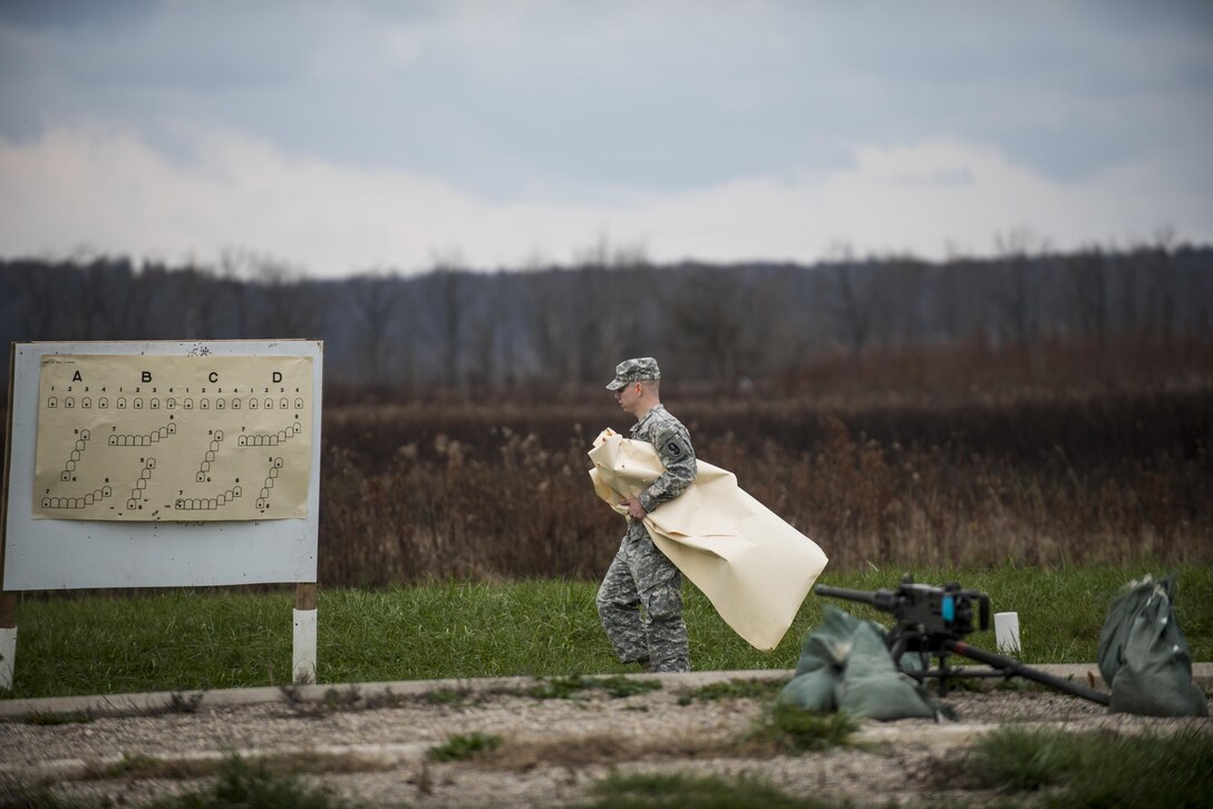 A U.S. Army Reserve Soldier with the 1st Battalion, 330th Infantry Regiment, of the 95th Infantry Division, rips down paper targets to prepare a range for military police Soldiers as part of an M2 Browning .50-caliber machine gun familiarization fire at Camp Atterbury, Ind., Nov. 5. The 384th Military Police Battalion, headquartered at Fort Wayne, Ind., organized a three-day range and field training exercise involving more than 550 U.S. Army Reserve Soldiers and incorporated eight different weapons systems, plus combat patrolling and a rifle marksmanship competition at Camp Atterbury, Ind., Nov. 5-7. (U.S. Army photo by Master Sgt. Michel Sauret)